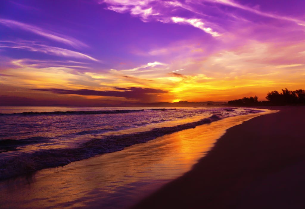 Vibrant sunset colors reflecting over a serene Brazilian beach, capturing nature's beauty.